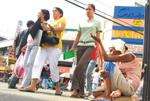 Seeking, begging. Amidst the hustle and bustle at the center of Iloilo City's Calle Real is this unidentified woman begging for food and money.