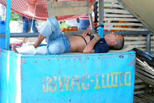 A vendor in downtown Iloilo City, appearing exhausted after a busy day, sleeps on top of his stall printed with City Mayor Jerry Treñas's slogan “Uswag Iloilo”. 