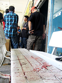 Police officers huddle beside a long plastic chair splattered with blood. SPO3 Rafael Managuit was seated on the plastic chair when a hand grenade he was handling exploded yesterday morning.
