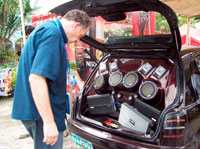 A judging official from Switzerland intricately checks the entry of the car audio competition.